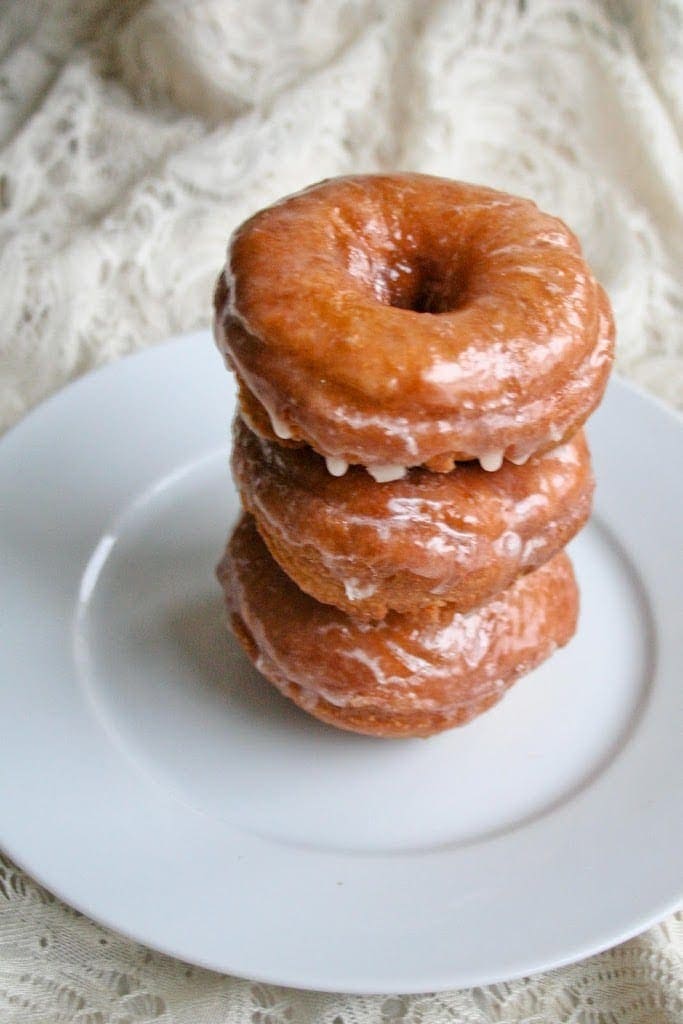 Homemade pumpkin donuts stacked on plate
