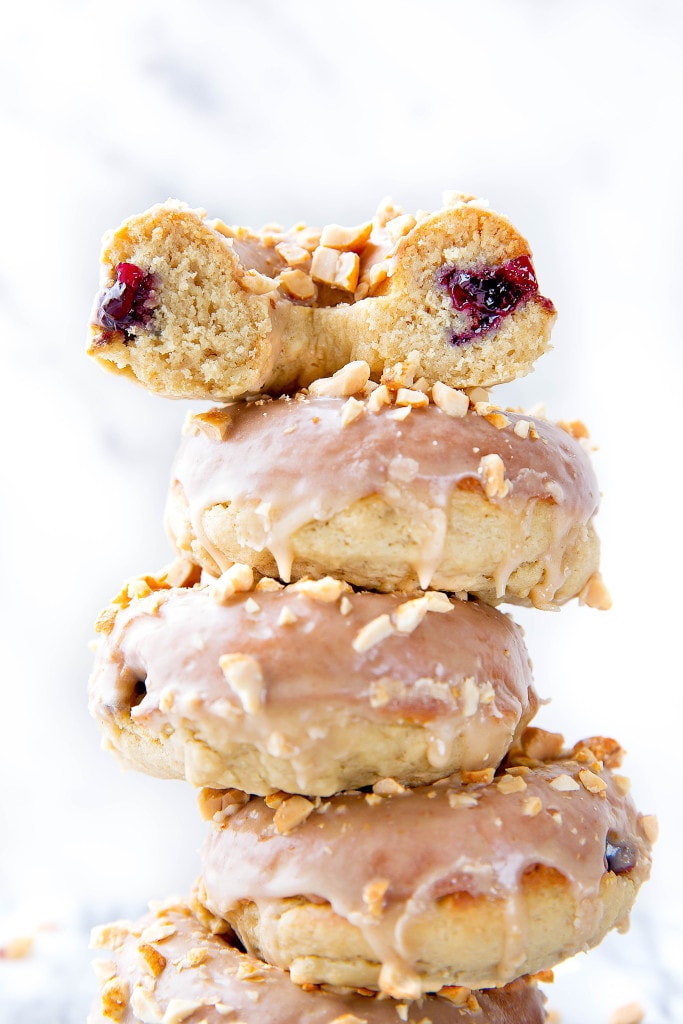 Your childhood favorite just got a makeover: Peanut Butter and Jelly Donuts stuffed with jelly and topped with peanut butter glaze and chopped peanuts!