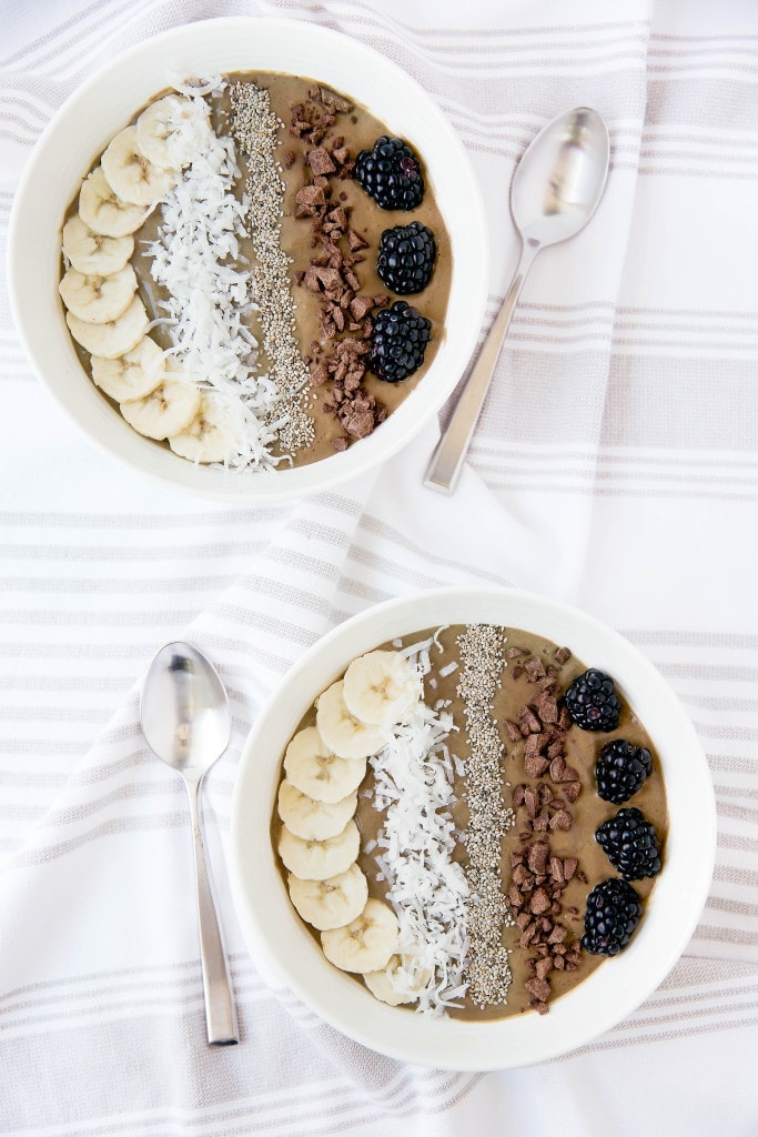chocolate smoothie bowls topped with fruit, coconut, and chocolate