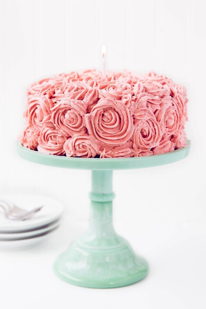 Almond Strawberry Cake with Strawberry Buttercream on a cake stand