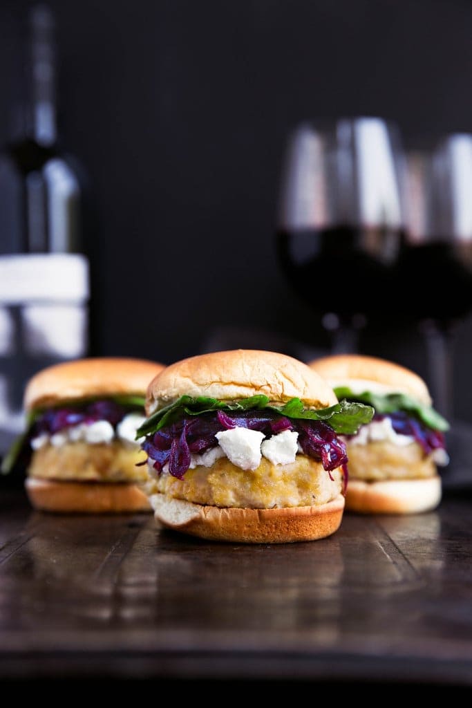 Say hello to these classy game-day buns: rosemary-infused turkey sliders topped with red wine caramelized onions, crumbled goat cheese, and arugula!