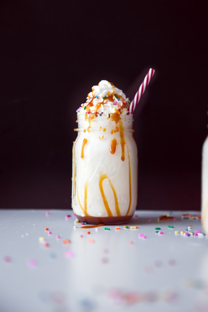 caramel milkshake in a glass jar with a straw