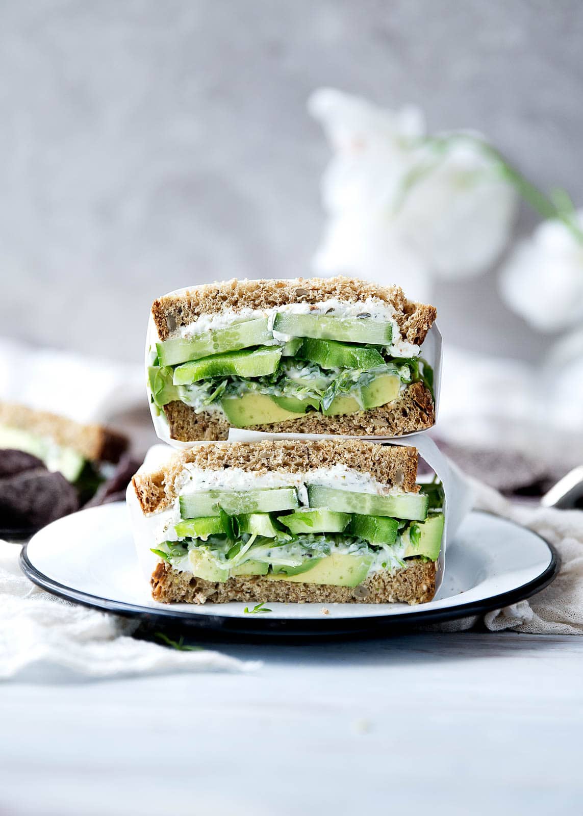 A green sandwich bursting at the seams with herbed goat cheese, avocado, alfalfa, and more.