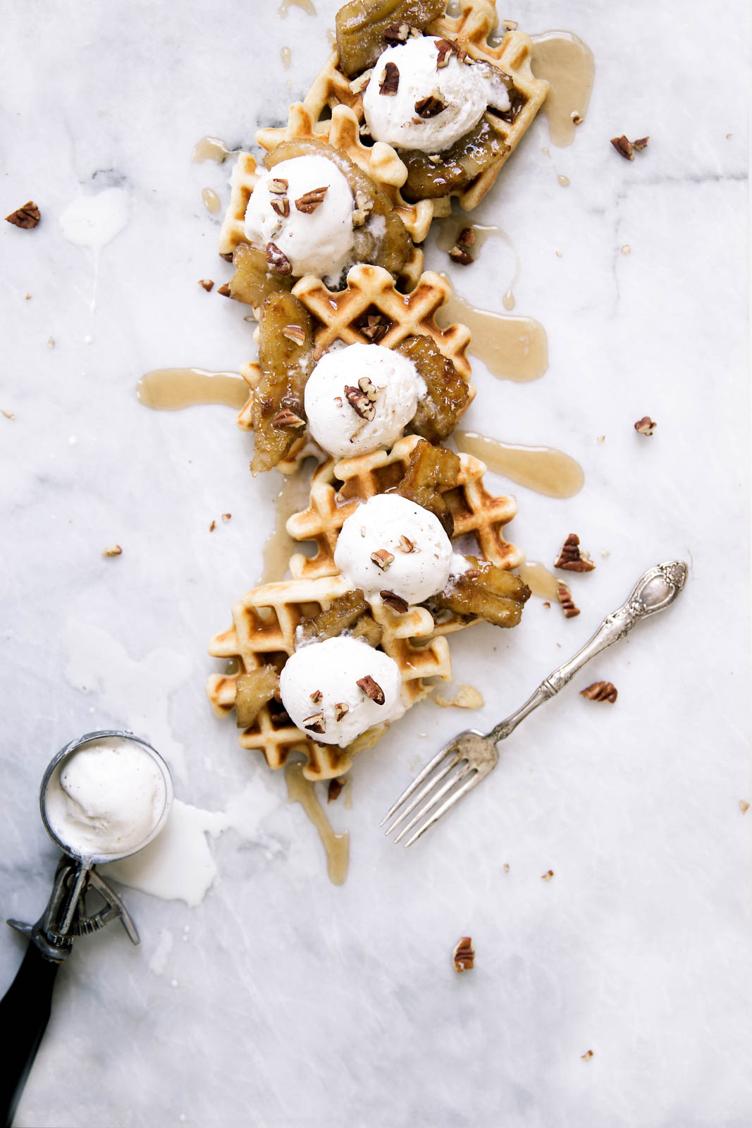 Bananas Foster Waffles made with vanilla ice cream, pecans, and caramelized rum bananas over a pillowy banana rum waffle. Yahm.