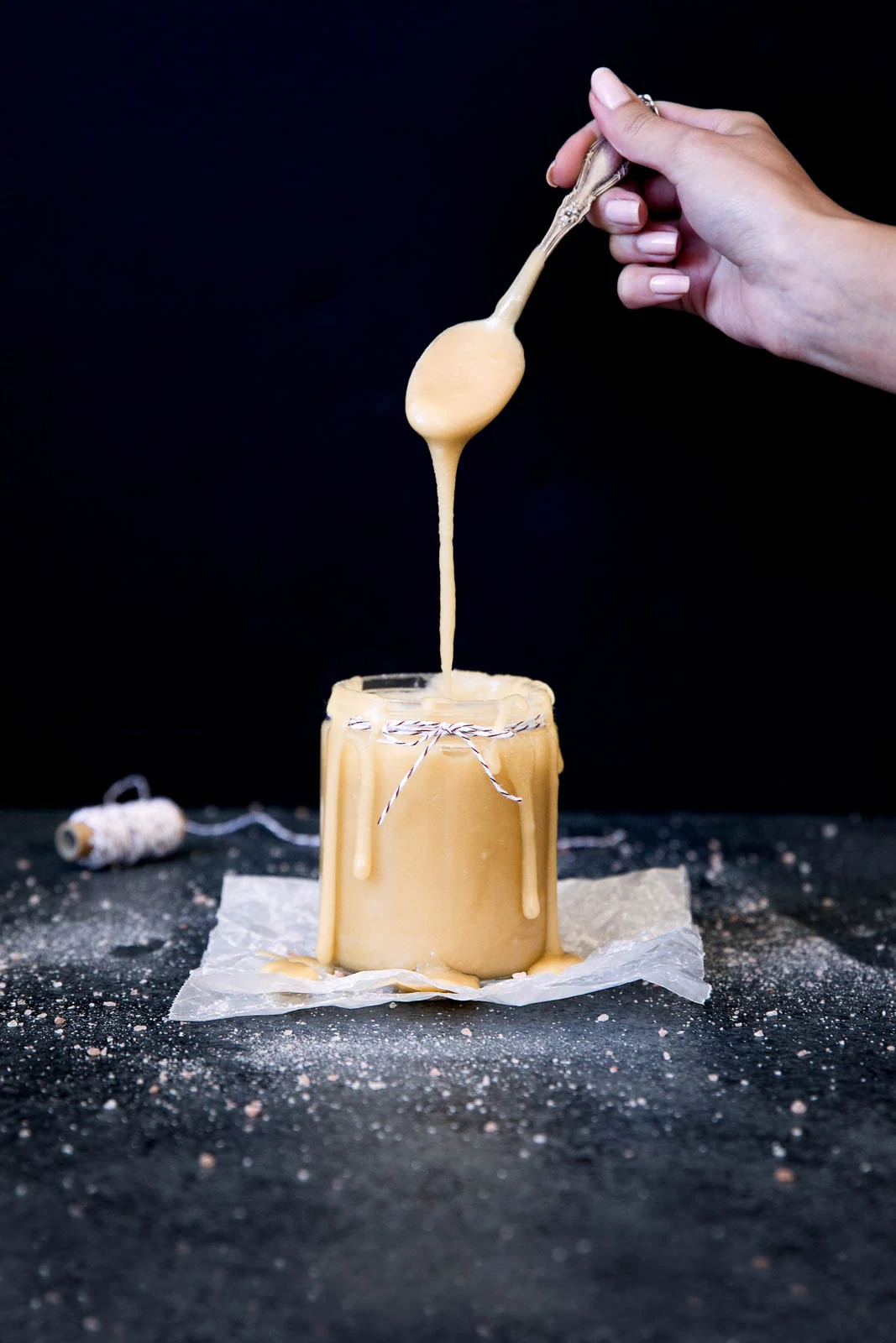 drizzling maple salted caramel sauce into a jar