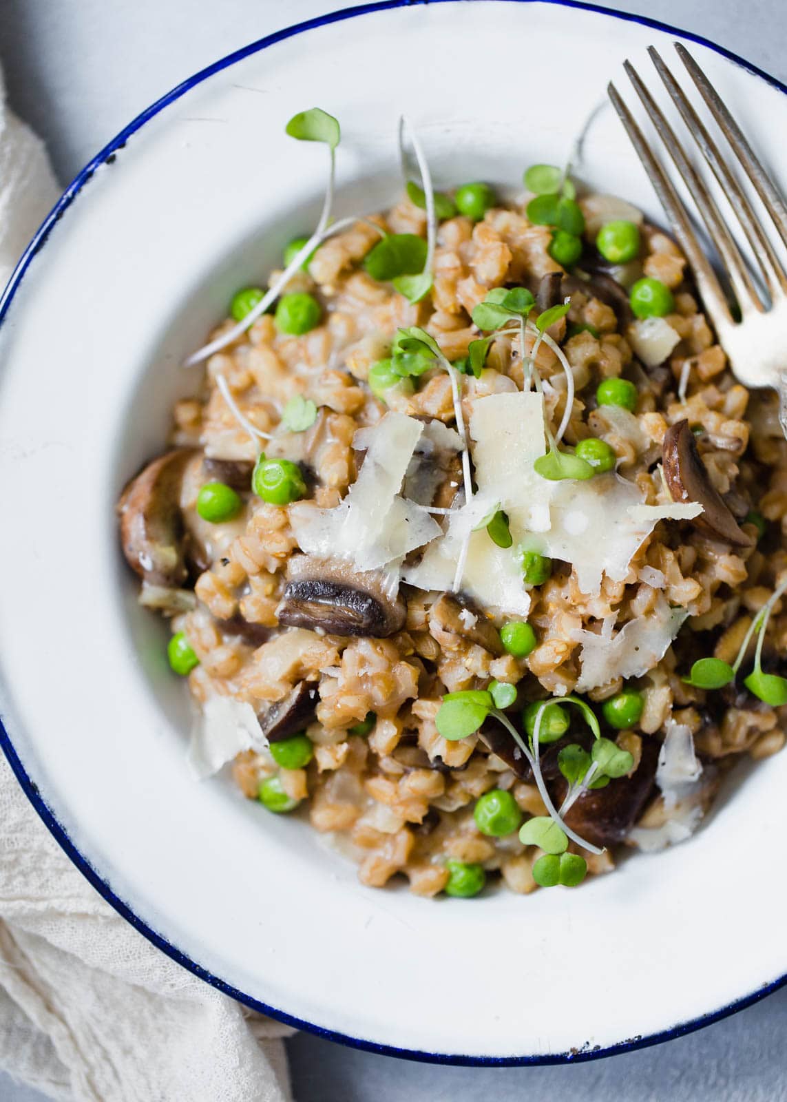 A warm and comforting farro risotto made with fresh spring peas and sautéed mushrooms!