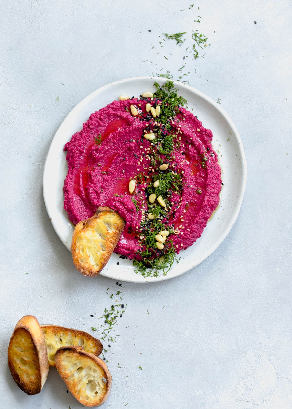 beet hummus in a bowl with bread