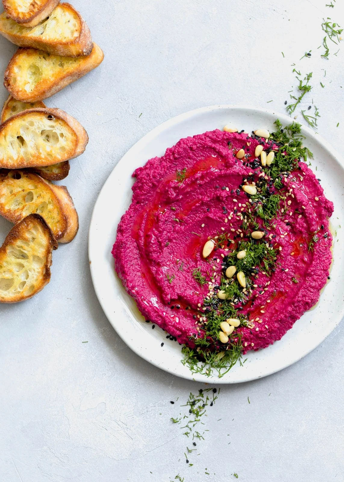 beet hummus topped with pine nuts and fresh dill