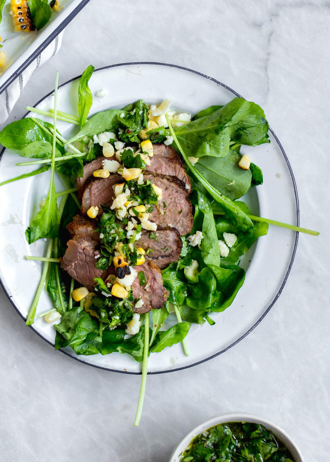 An epic Chimichurri Steak Salad with charred corn, cotija cheese, arugula, and a homemade chimichurri sauce. Perfect for summer nights!