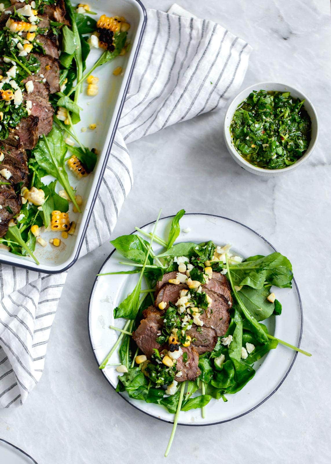 An epic Chimichurri Steak Salad with charred corn, cotija cheese, arugula, and a homemade chimichurri sauce. Perfect for summer nights!