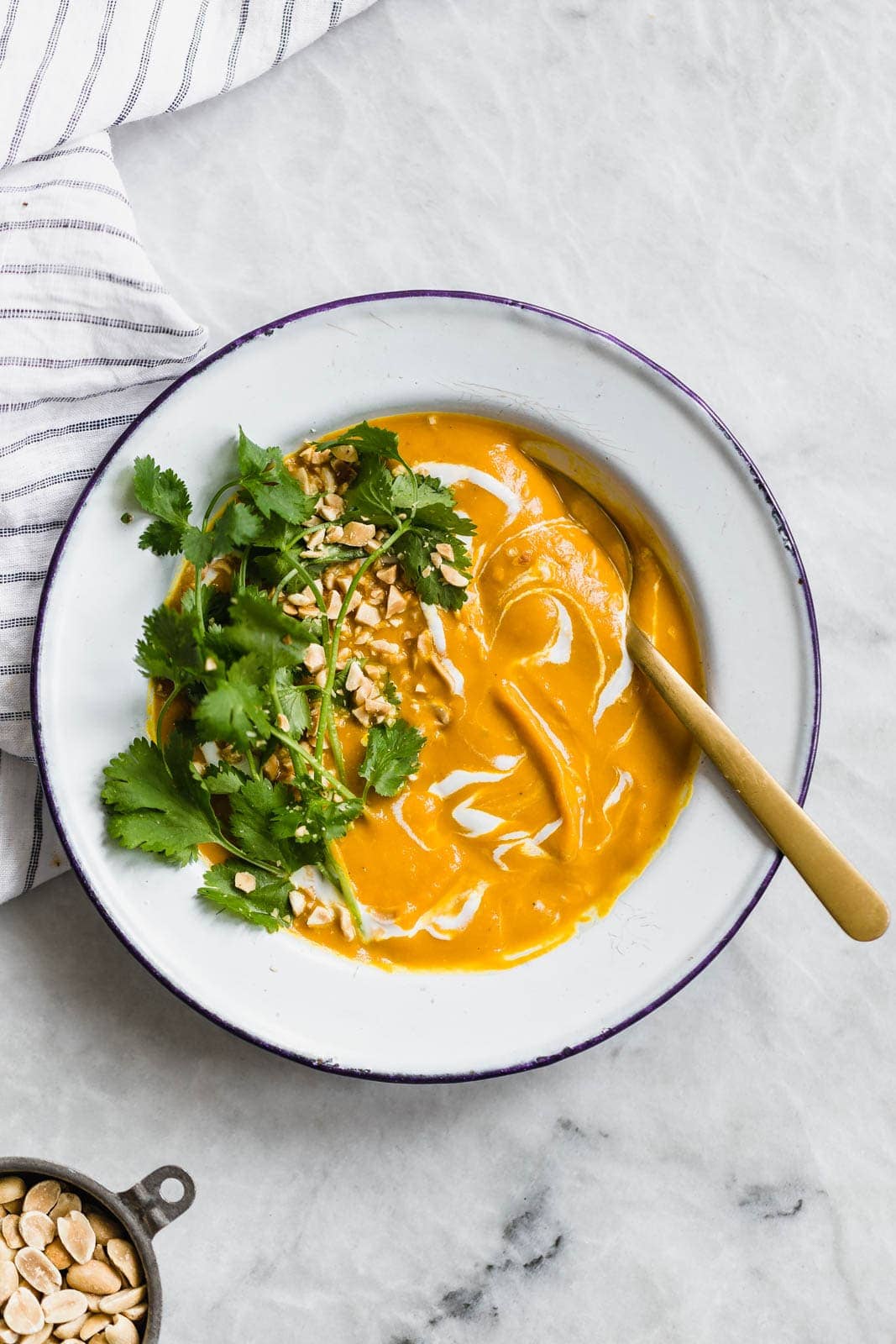 Vegan Turmeric Carrot Ginger Soup topped with cilantro and peanuts
