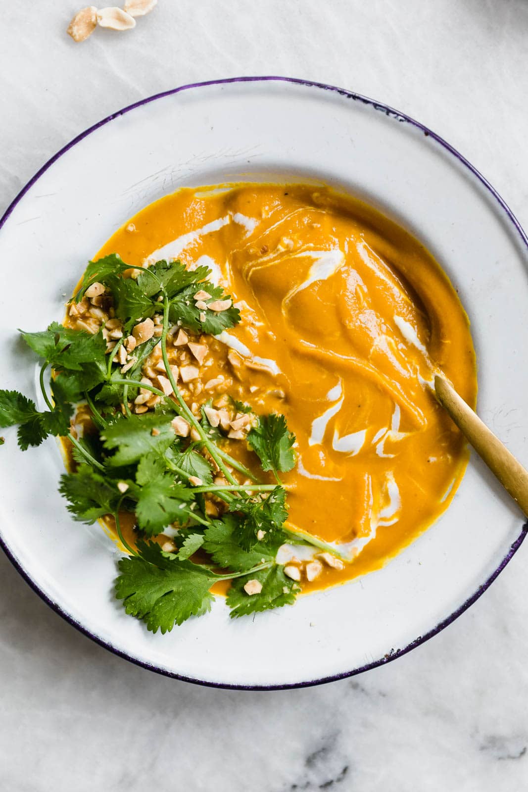 Vegan Turmeric Carrot Ginger Soup in bowl with spoon