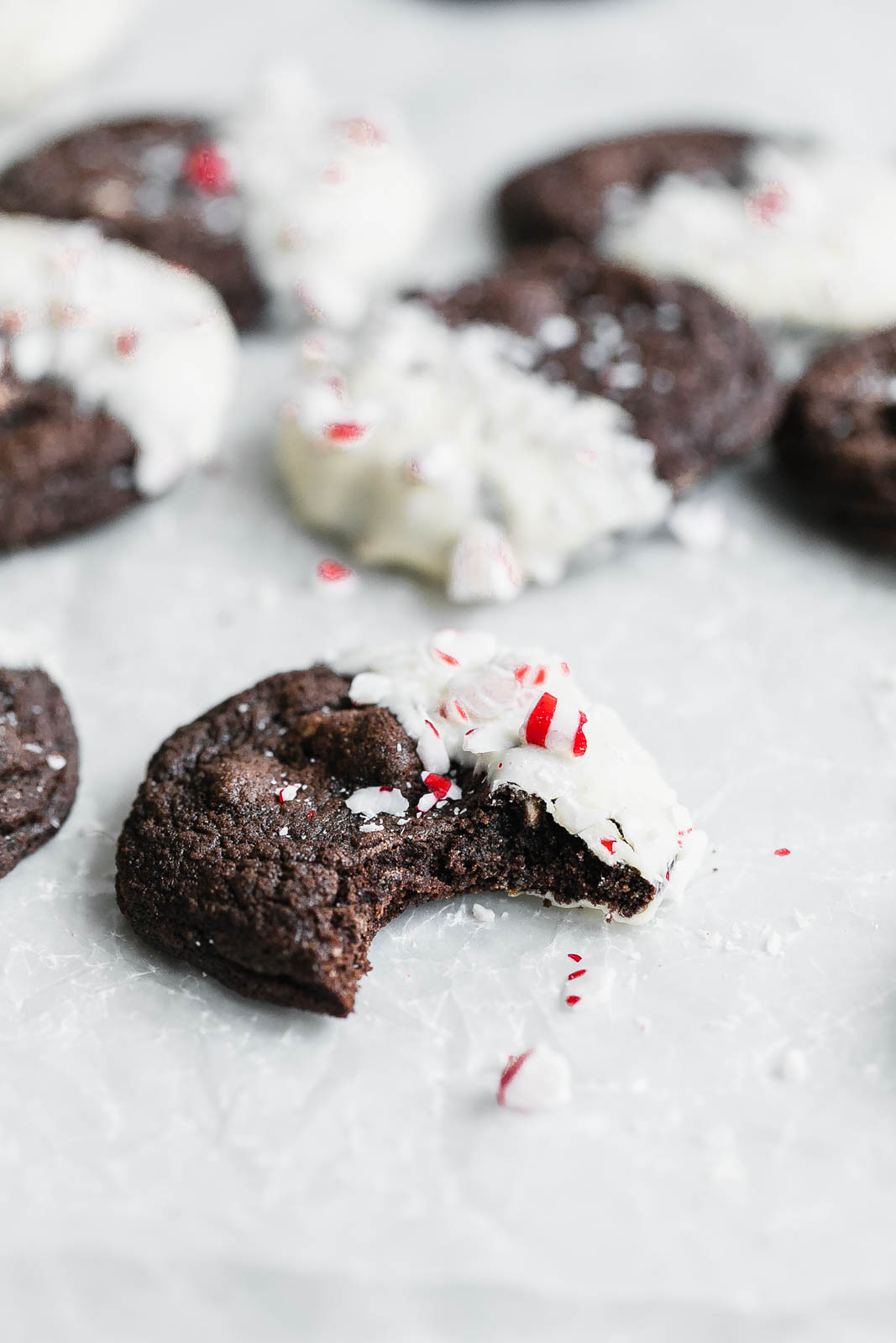 A chewy Chocolate White Chocolate Peppermint Cookie dipped in white chocolate and covered in peppermint candies. So perfect for the holidays!