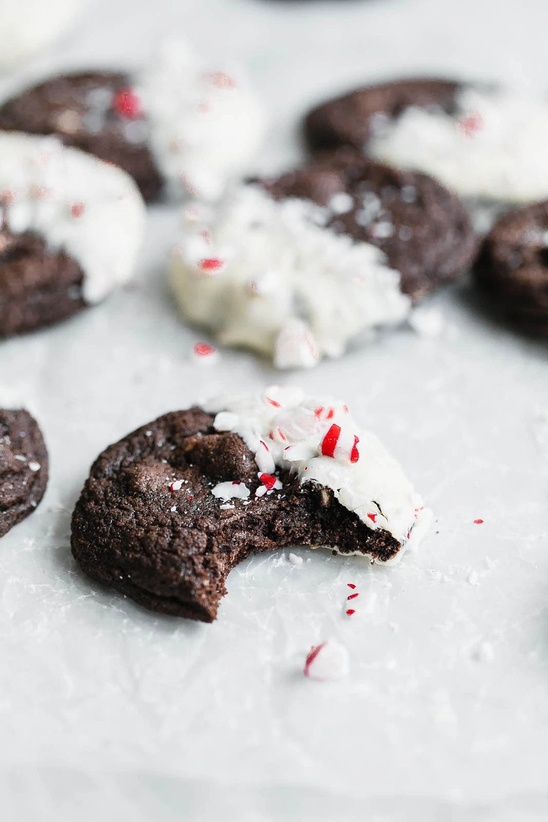A chewy Chocolate White Chocolate Peppermint Cookie dipped in white chocolate and covered in peppermint candies. So perfect for the holidays!