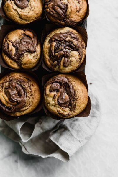 The softest, most moist Nutella Swirled Banana Muffins. Warning: do not eat these without a friend, because you will eat them all.