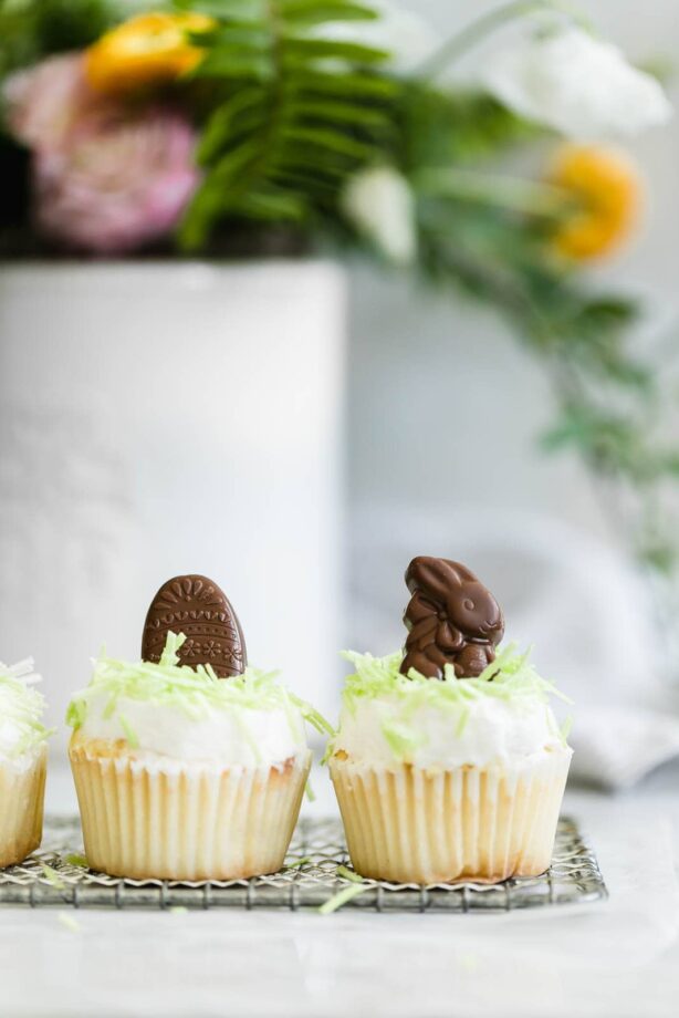 Easter Bunny Cupcakes: a perfect vanilla cupcake topped with buttercream, green “grass,” and caramel-filled chocolate Easter bunnies!