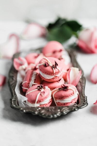 Raspberry Rose Macarons made with rosewater, a vanilla buttercream, and a surprise raspberry preserve center. Simple, elegant, and oh so delicious!!