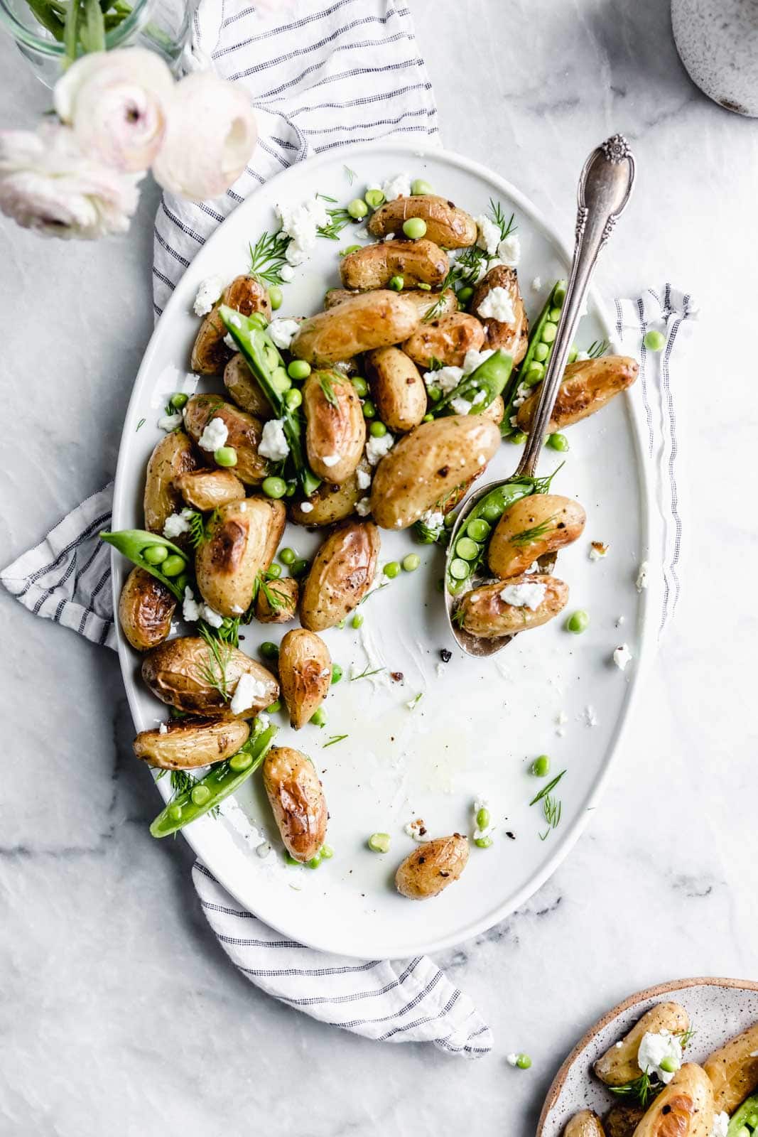 These roasted fingerling potatoes with dill, goat cheese, and peas are our new fav side dish. Full of texture and flavor, you'll love these spring potatoes.