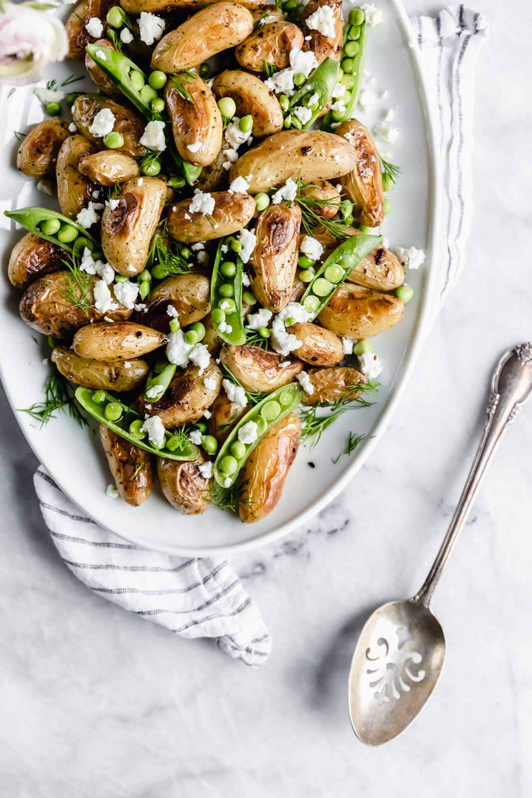 These roasted fingerling potatoes with dill, goat cheese, and peas are our new fav side dish. Full of texture and flavor, you'll love these spring potatoes.
