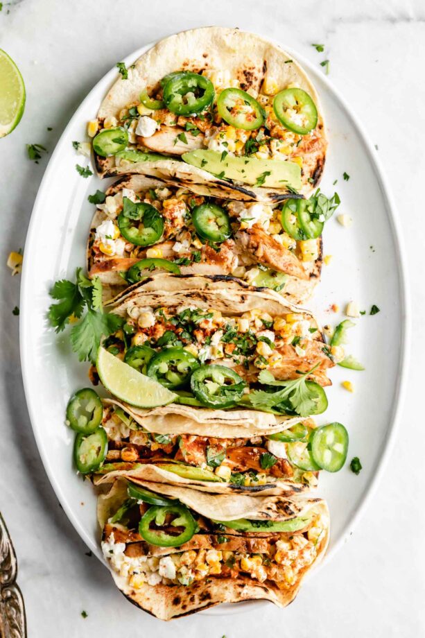 Loaded BBQ Chicken Street Corn Tacos made with fresh corn, crema, avocado, tender chicken, and cotija cheese. What more could you ask for?