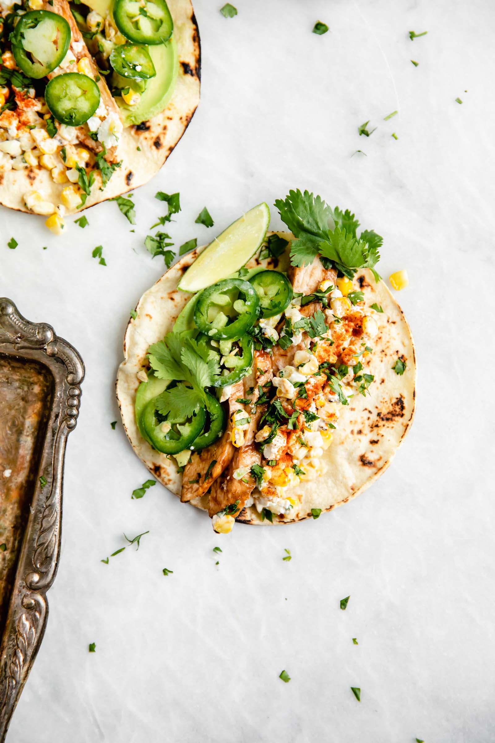 Kicking off Summer Taco Tuesdays with BBQ Chicken Mexican Street Corn tacos loaded with crema, cotija cheese, avocado, and fresh corn. Sign me up!