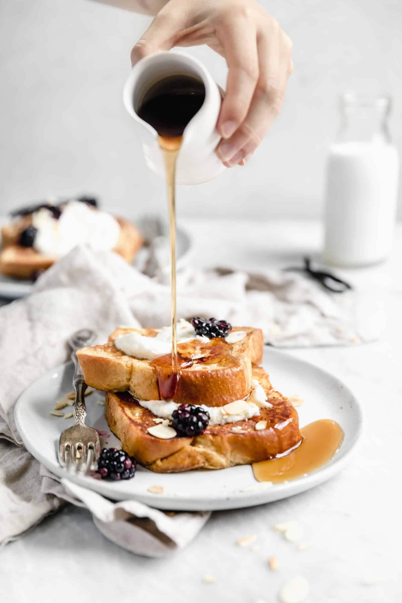bourbon vanilla french toast being drizzled with maple syurp