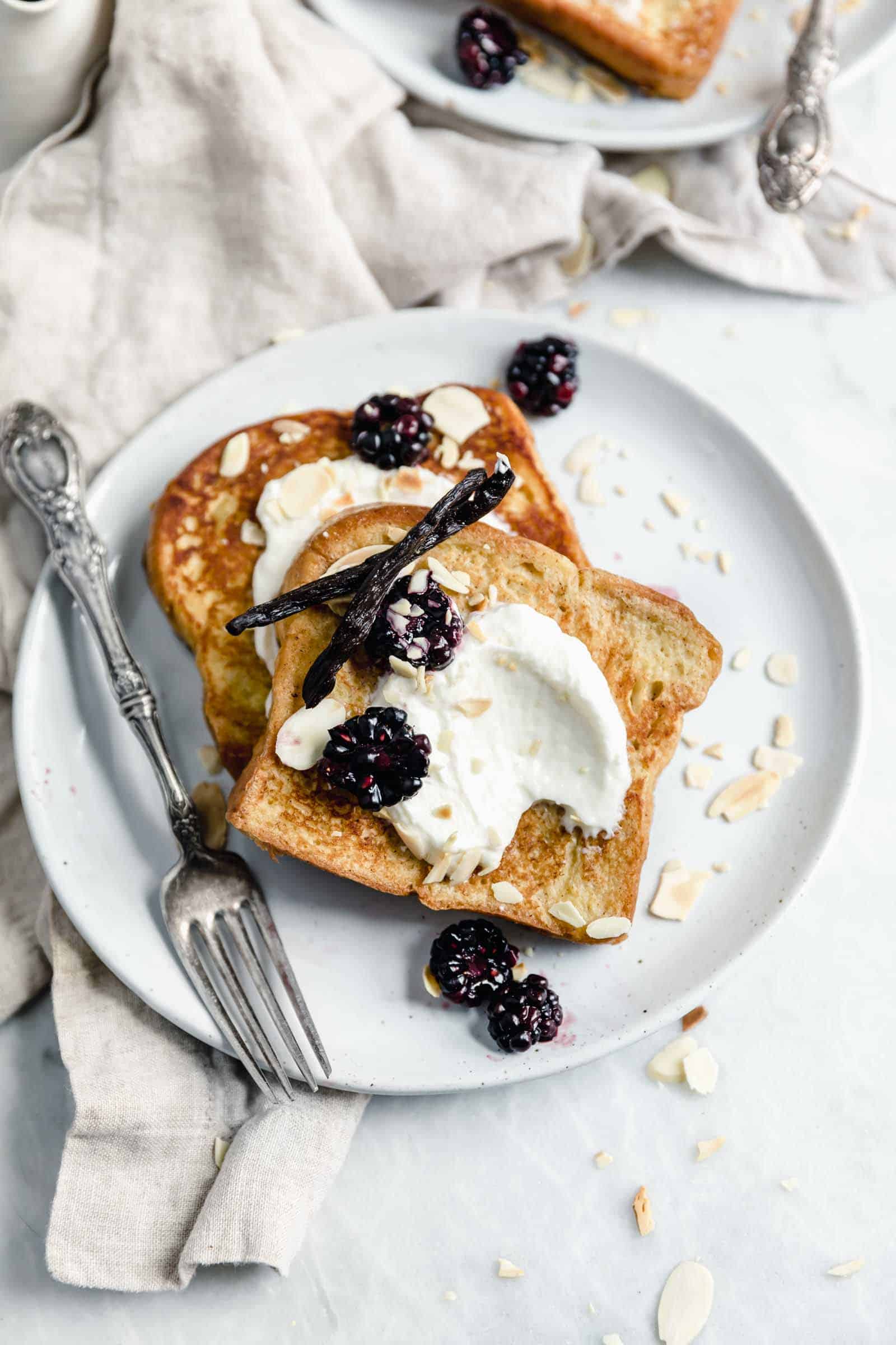 overhead shot of plate of french toast with whipped cream and berries