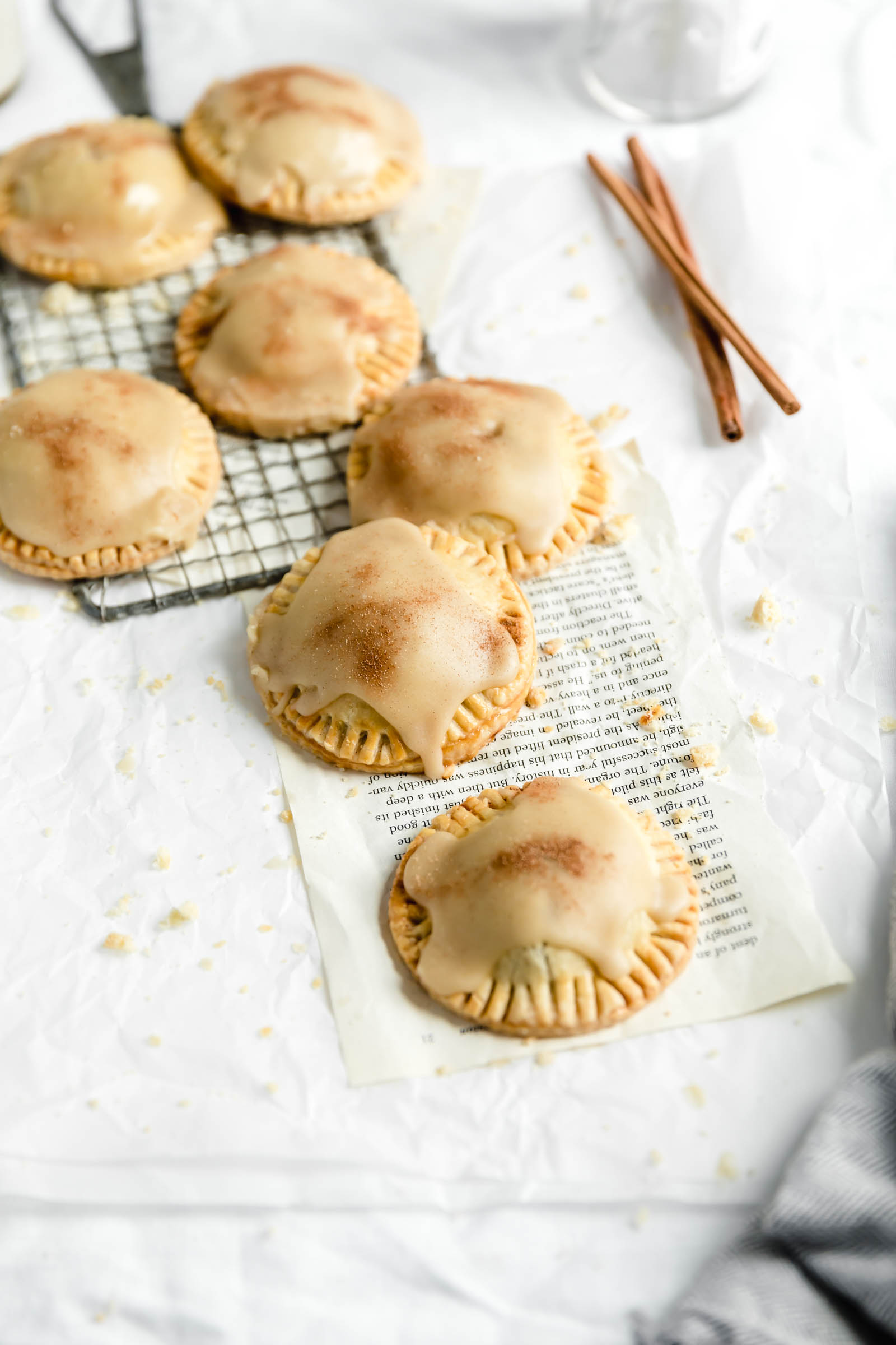 mini apple hand pies covered in maple glaze scattered over counter