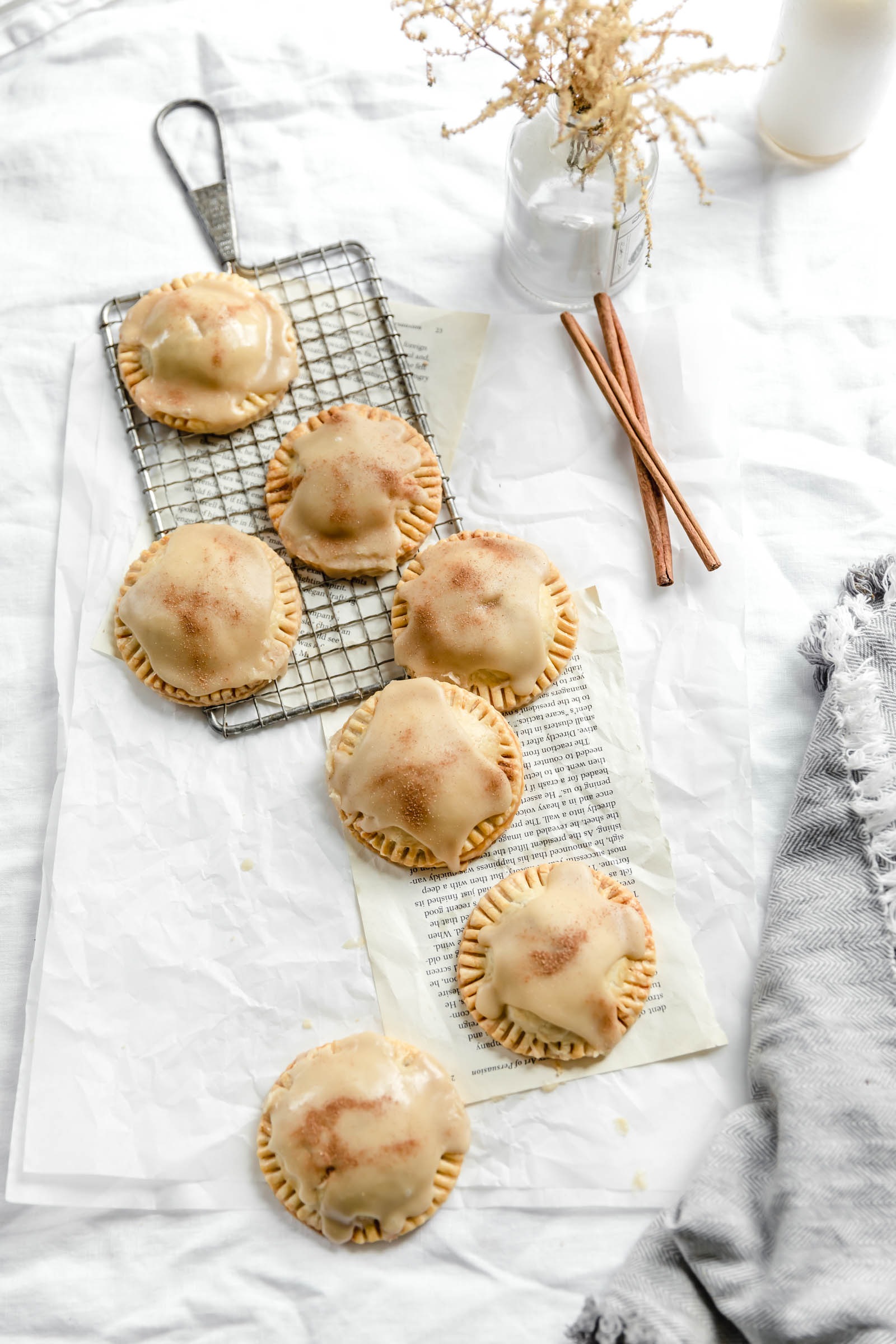 apple pies scattered over cooling rack and parchment paper