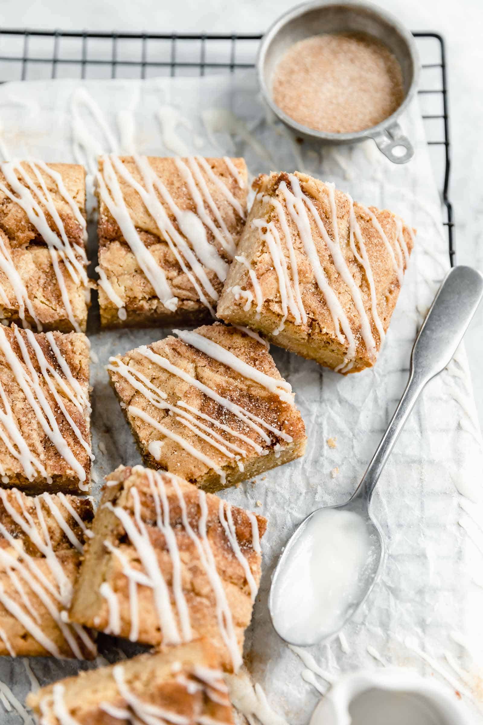 cinnamon roll blondies cut into squares on a cooling rack