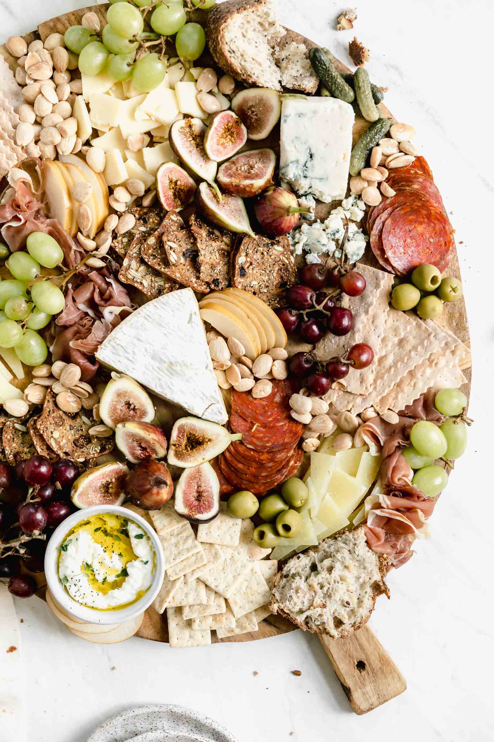 instagrammable cheeseboard loaded with cheese, meats, almonds, olives, and crackers