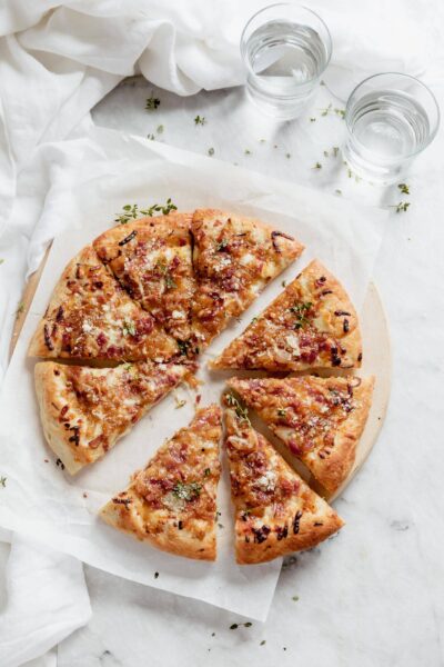 caramelized onion bacon and gruyere pizza pie cut into triangles