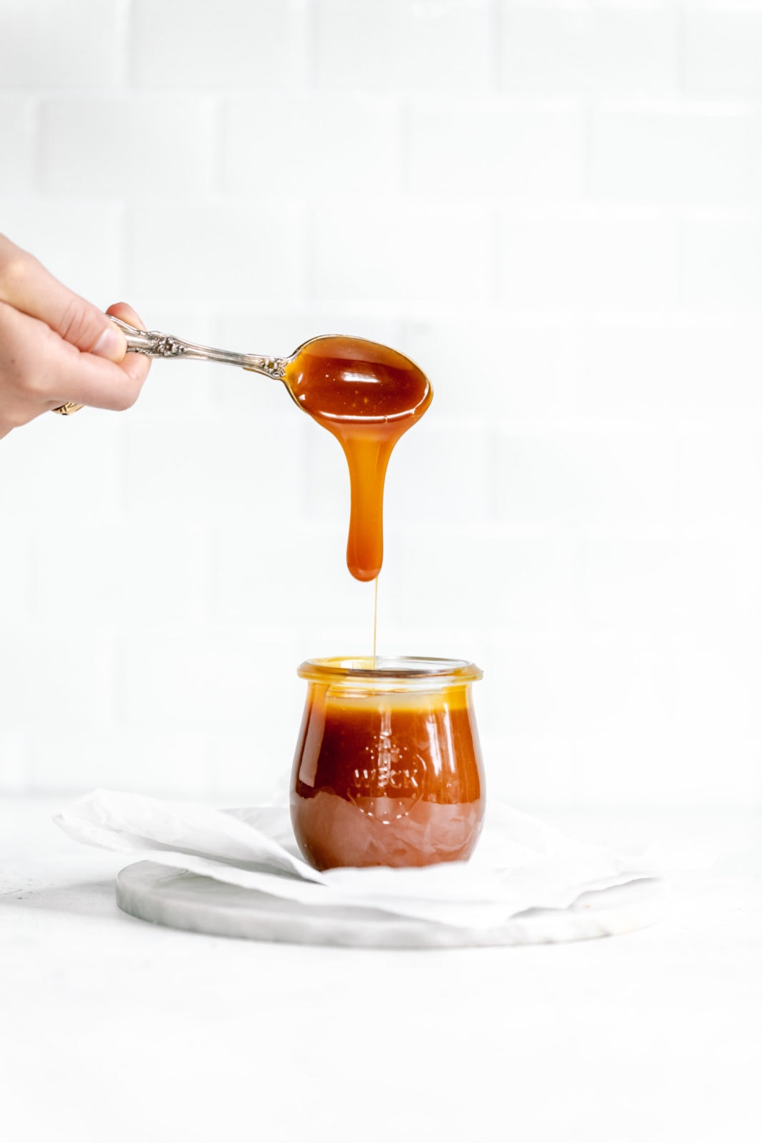salted caramel dripping off spoon in to a jar