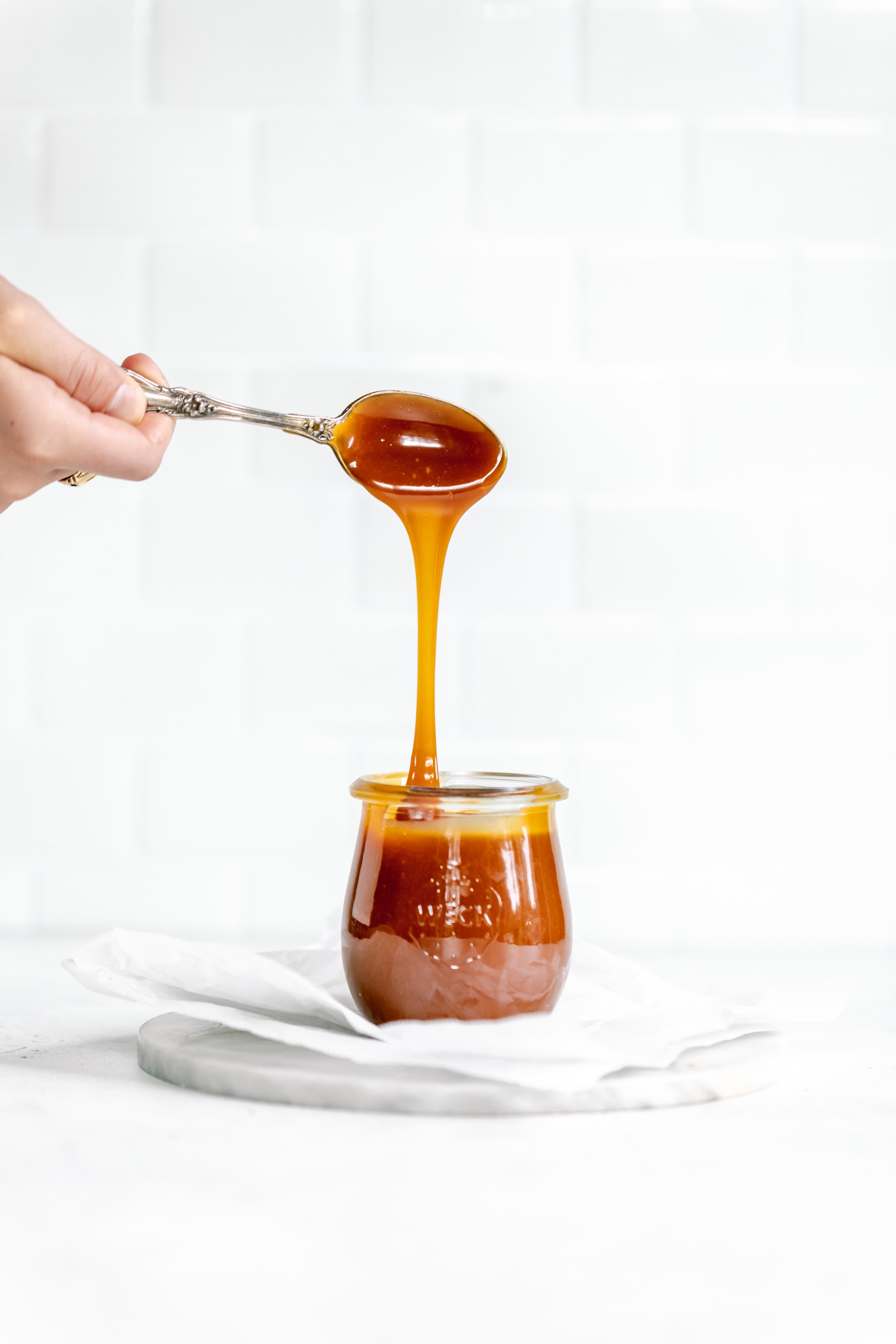 salted caramel dripping into jar off of spoon
