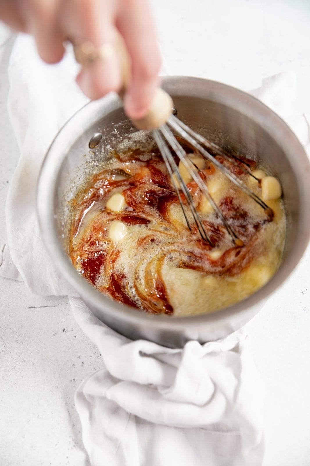 whisking butter into caramel sauce