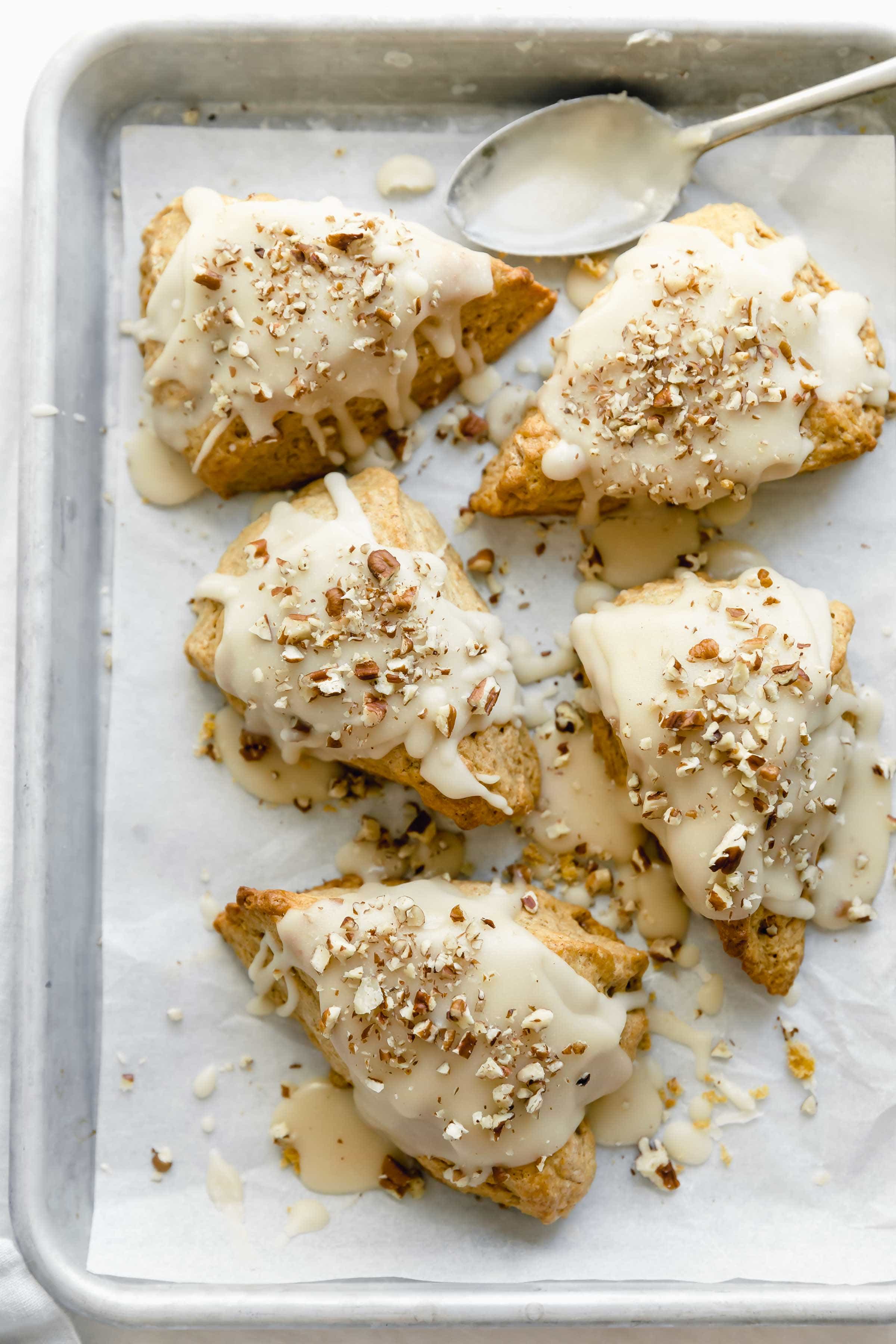 thick and moist pumpkin scones with a decadent maple glaze and chopped pecans