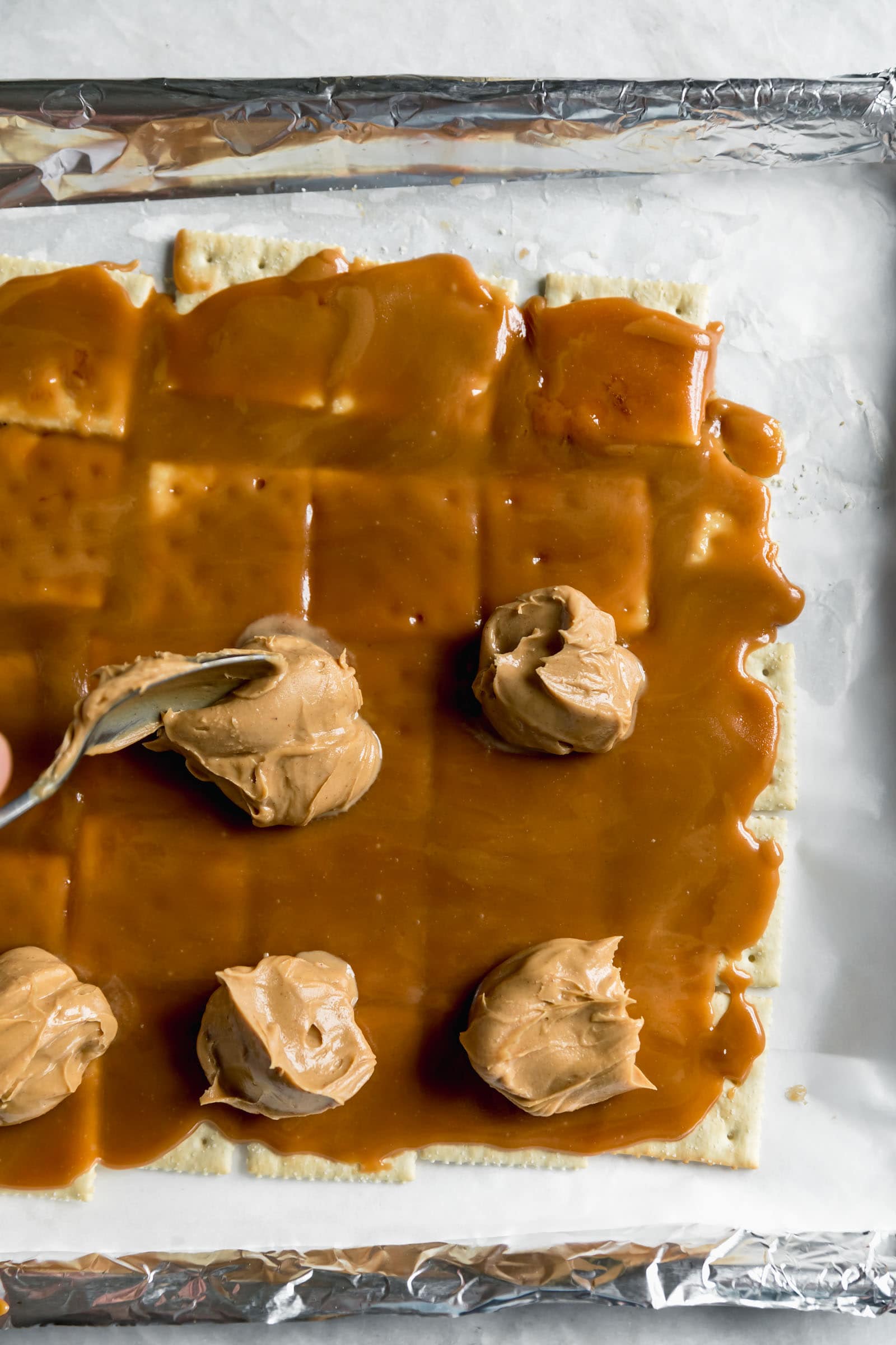 peanut butter dropped by spoonful on saltines