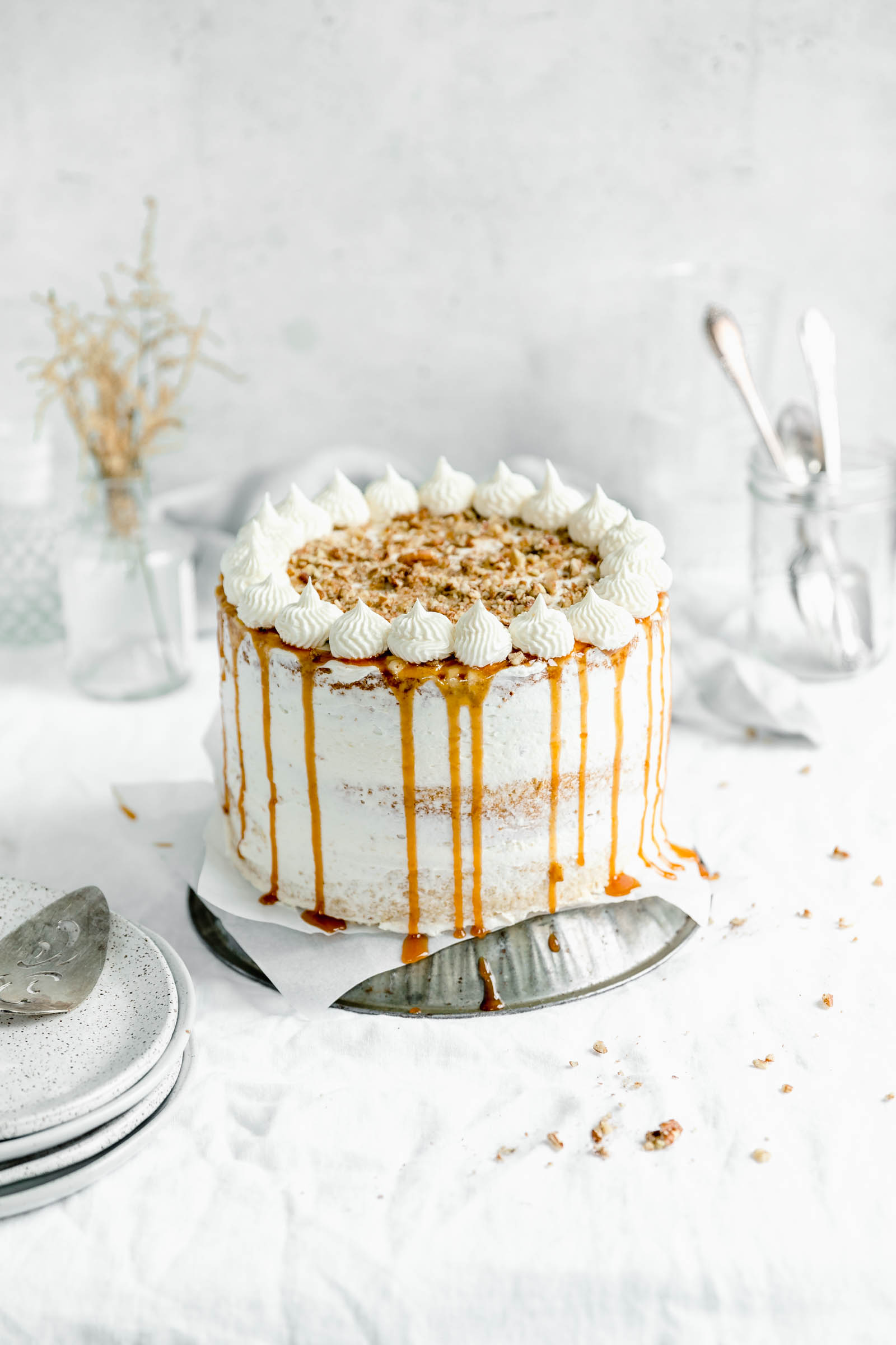 This decadent praline layer cake is the perfect centerpiece for all your Fall celebrations! Made with a moist and tender vanilla cake sandwiched together with a gooey homemade praline feeling and frosted with fluffy buttercream. Um YES. #bromabakery #pralinelayercake #foodphotography