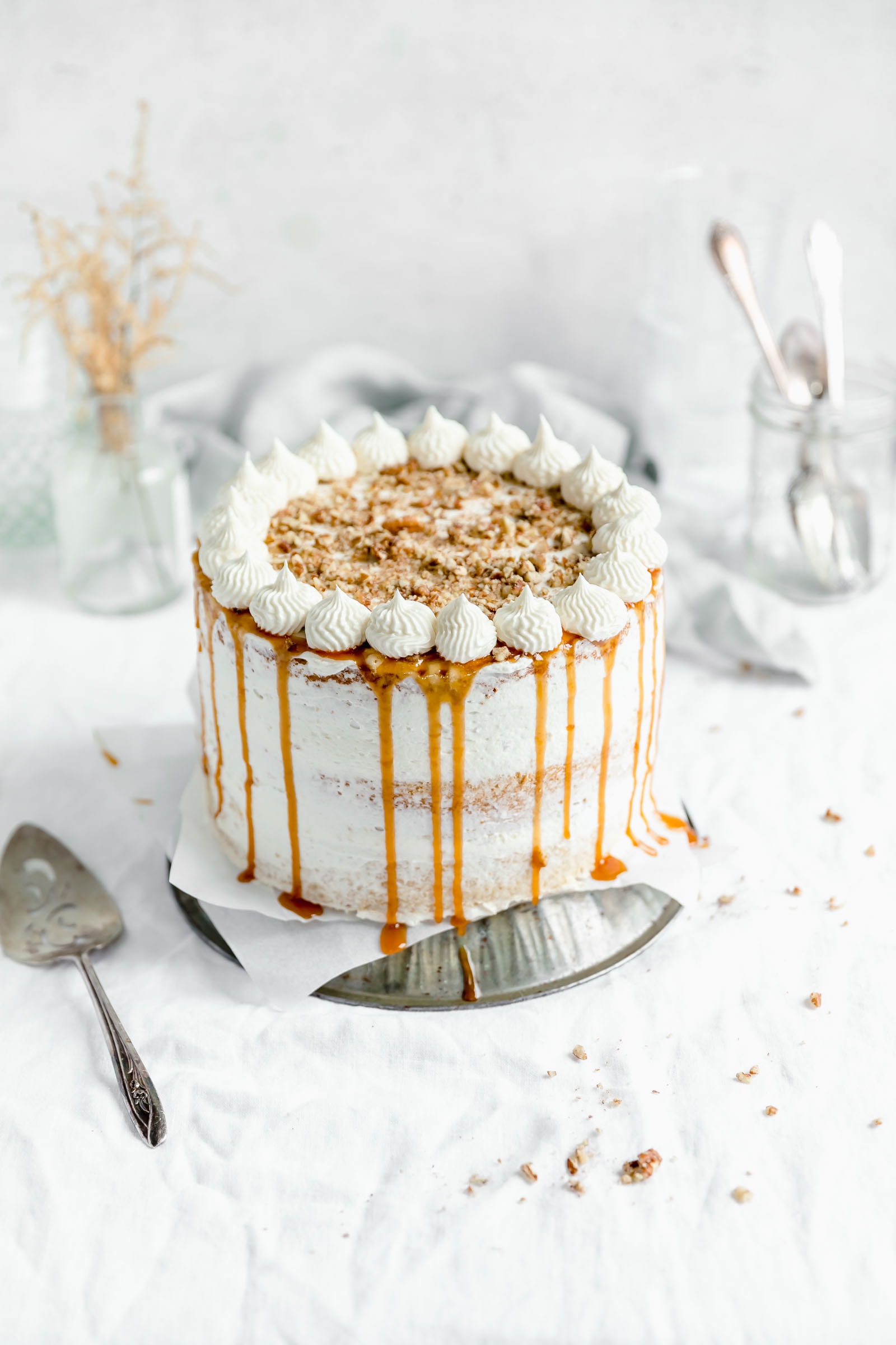 This decadent praline layer cake is the perfect centerpiece for all your Fall celebrations! Made with a moist and tender vanilla cake sandwiched together with a gooey homemade praline feeling and frosted with fluffy buttercream. Um YES. #bromabakery #pralinelayercake #foodphotography