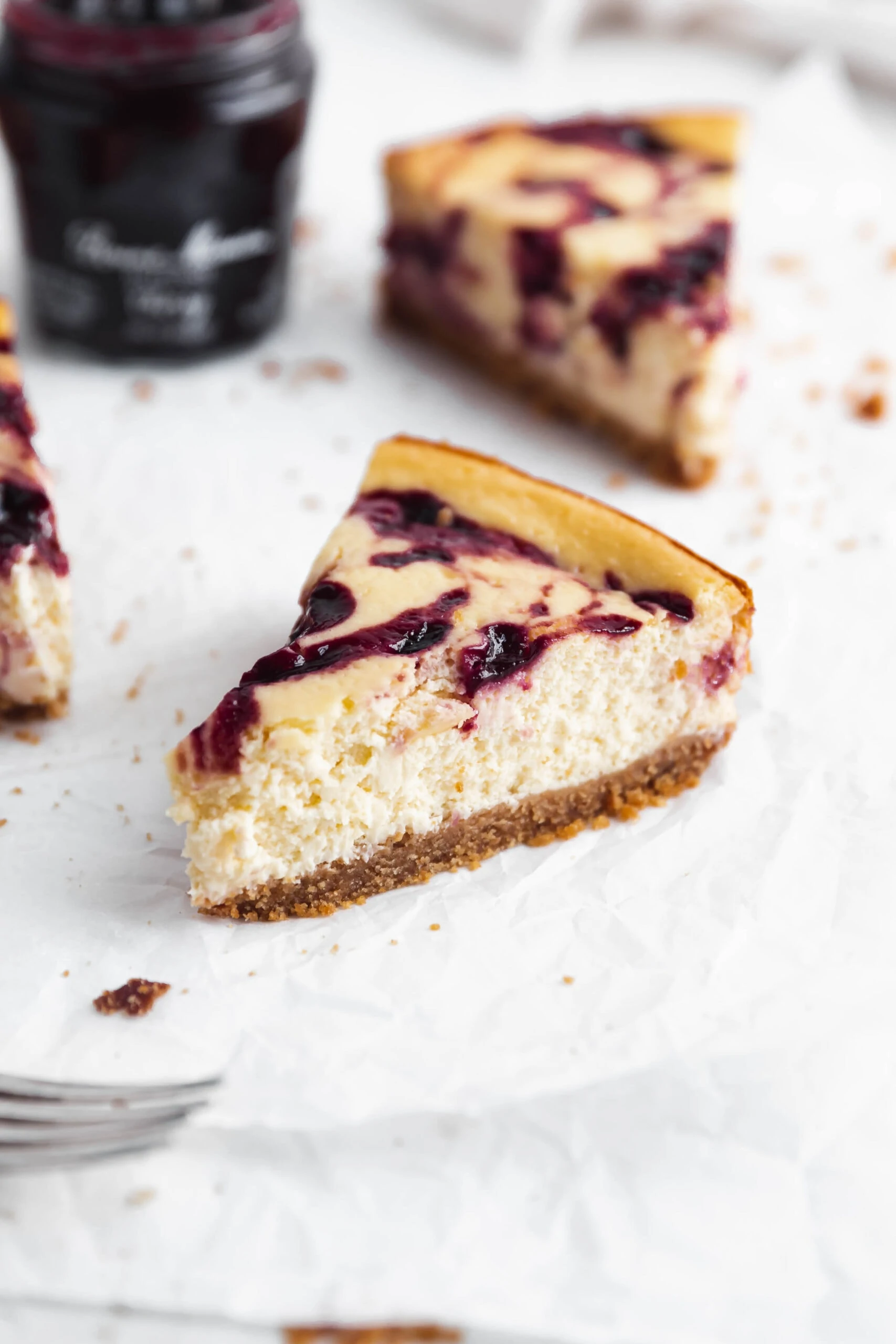 slice of healthy cherry cheesecake with big swirls of cherry jam and a graham cracker crust