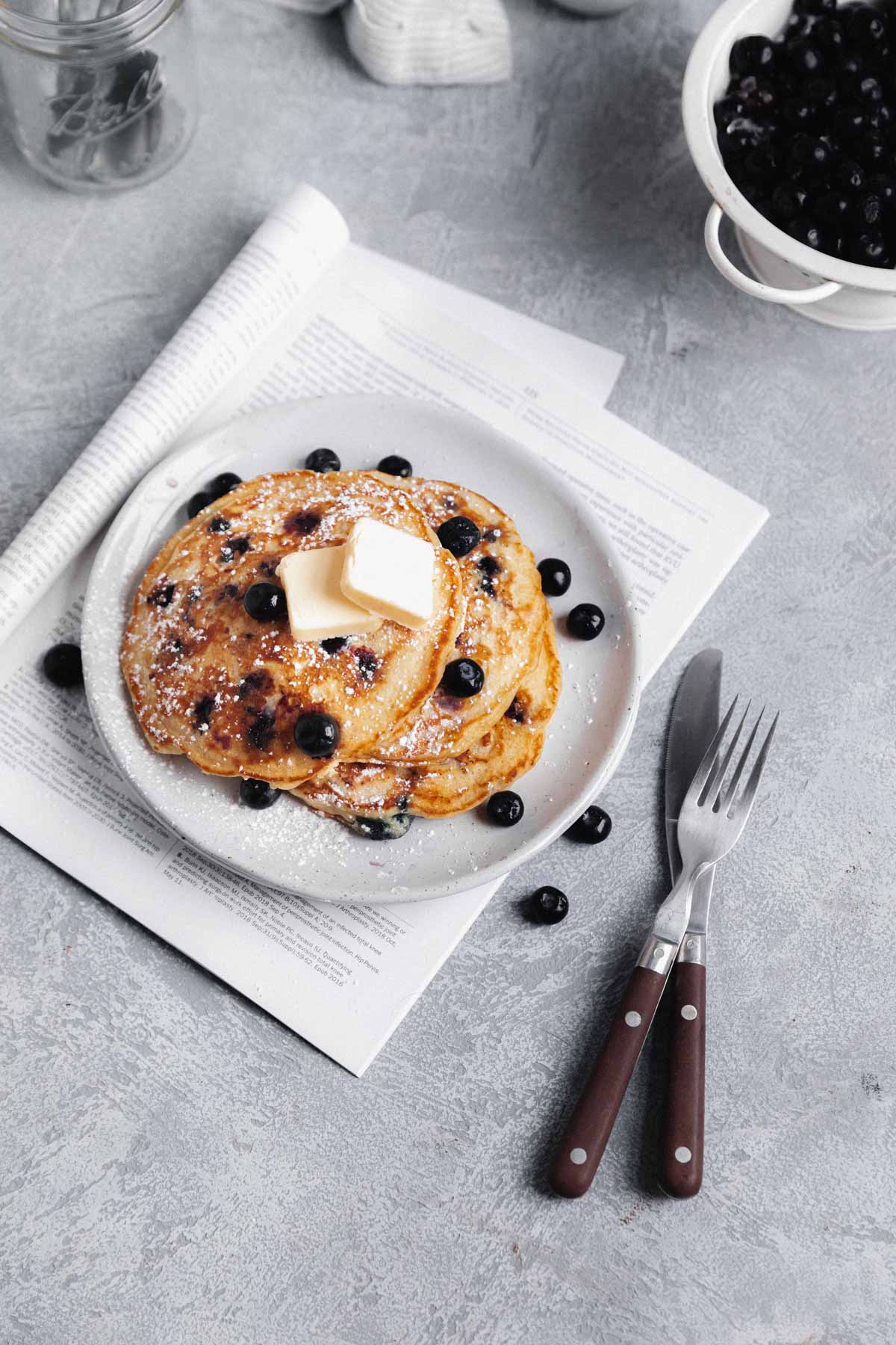 blueberry pancakes topped with more blueberries and butter