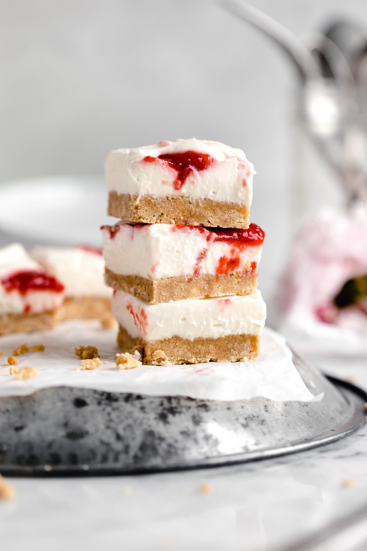 stack of no bake cheesecake bars with a strawberry swirl