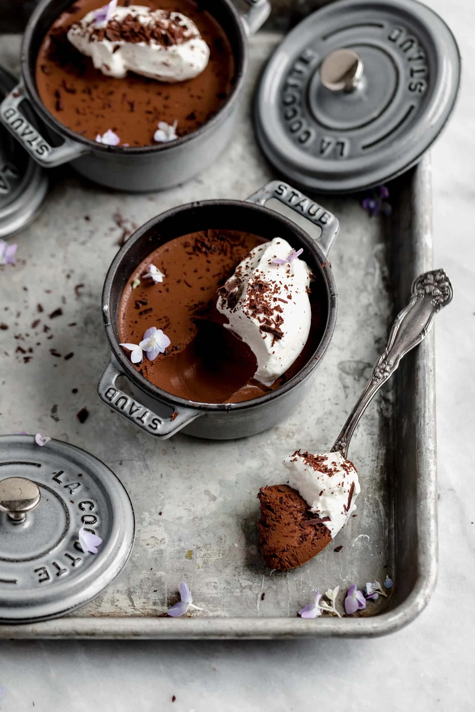chocolate mousse in a ramekin with a spoonful of mousse and whipped cream