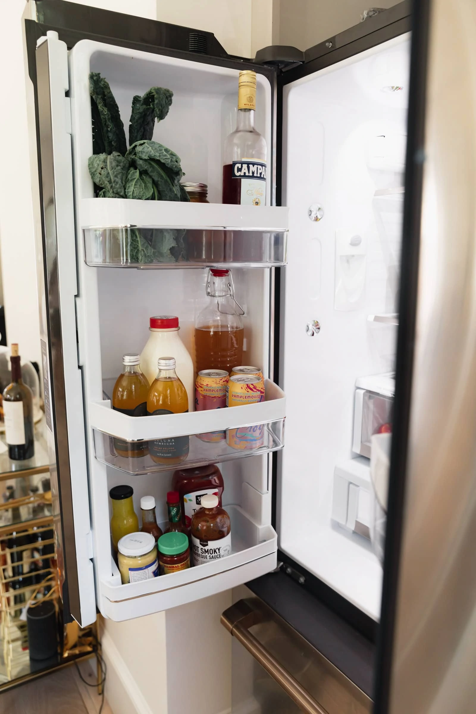 fridge door with drinks, condiments and food