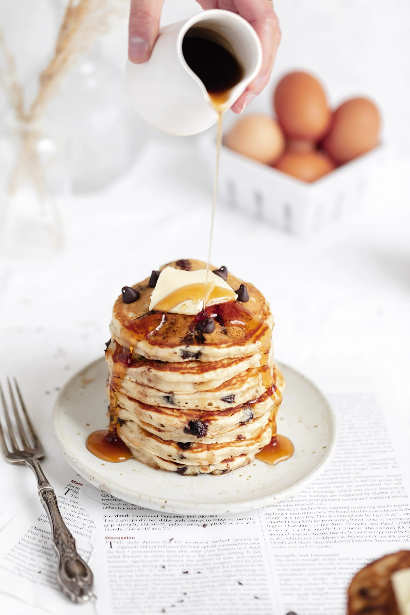 perfect chocolate chip pancakes in a stack with maple syrup