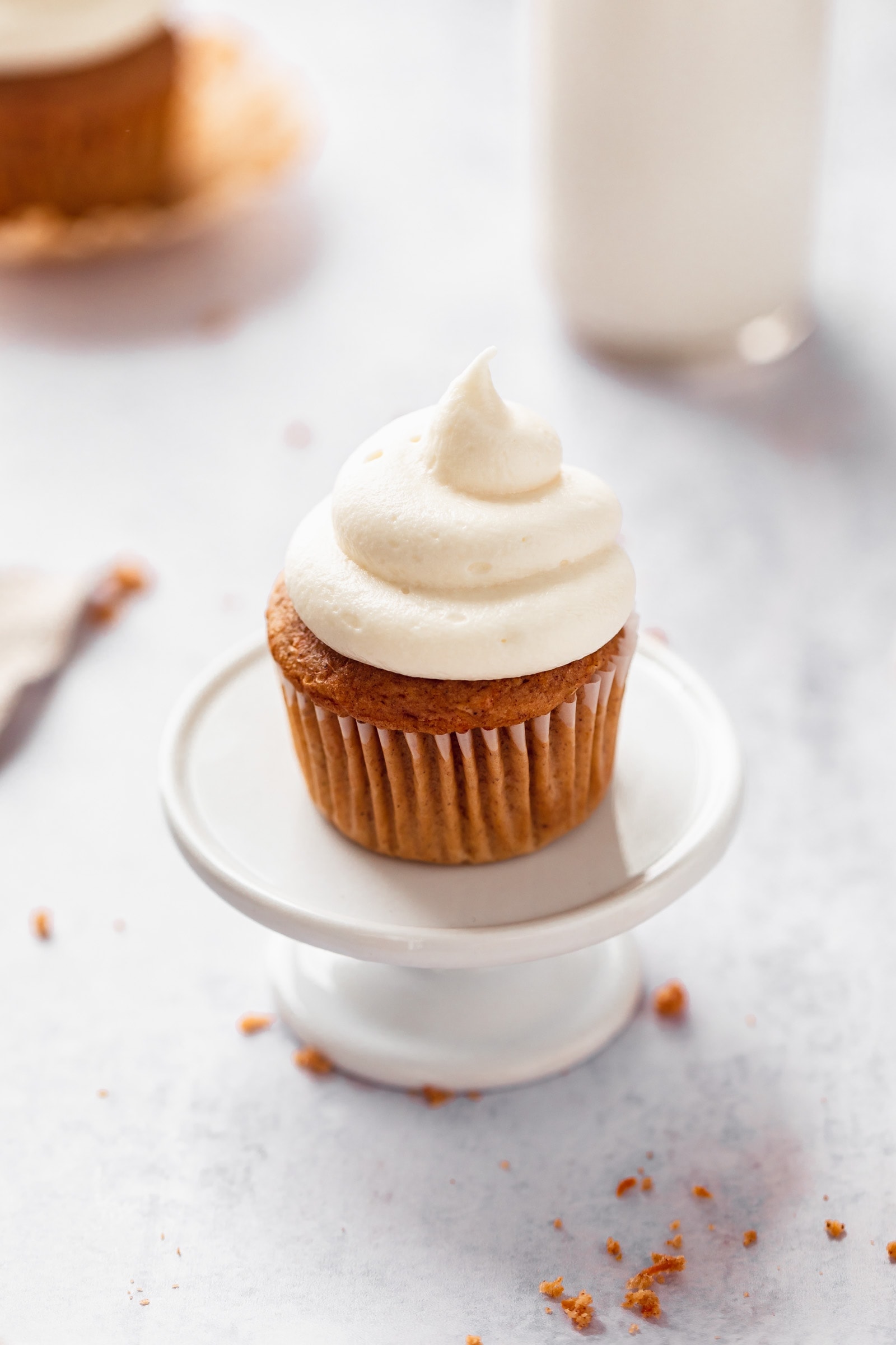 perfect fluffy cream cheese frosting piped on a carrot cake cupcake