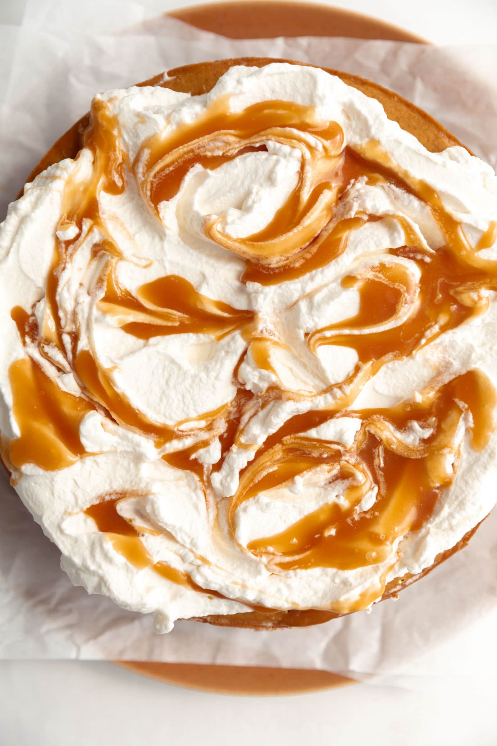 whipped cream and caramel on top of pumpkin cheesecake