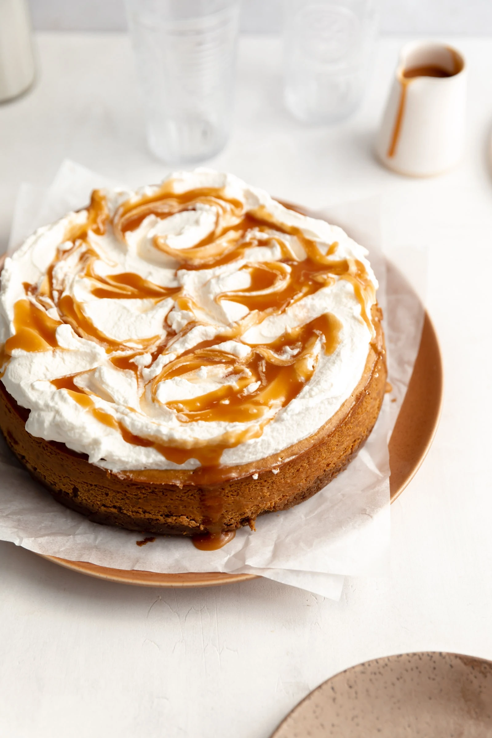 pumpkin cheesecake topped with whipped cream and salted caramel