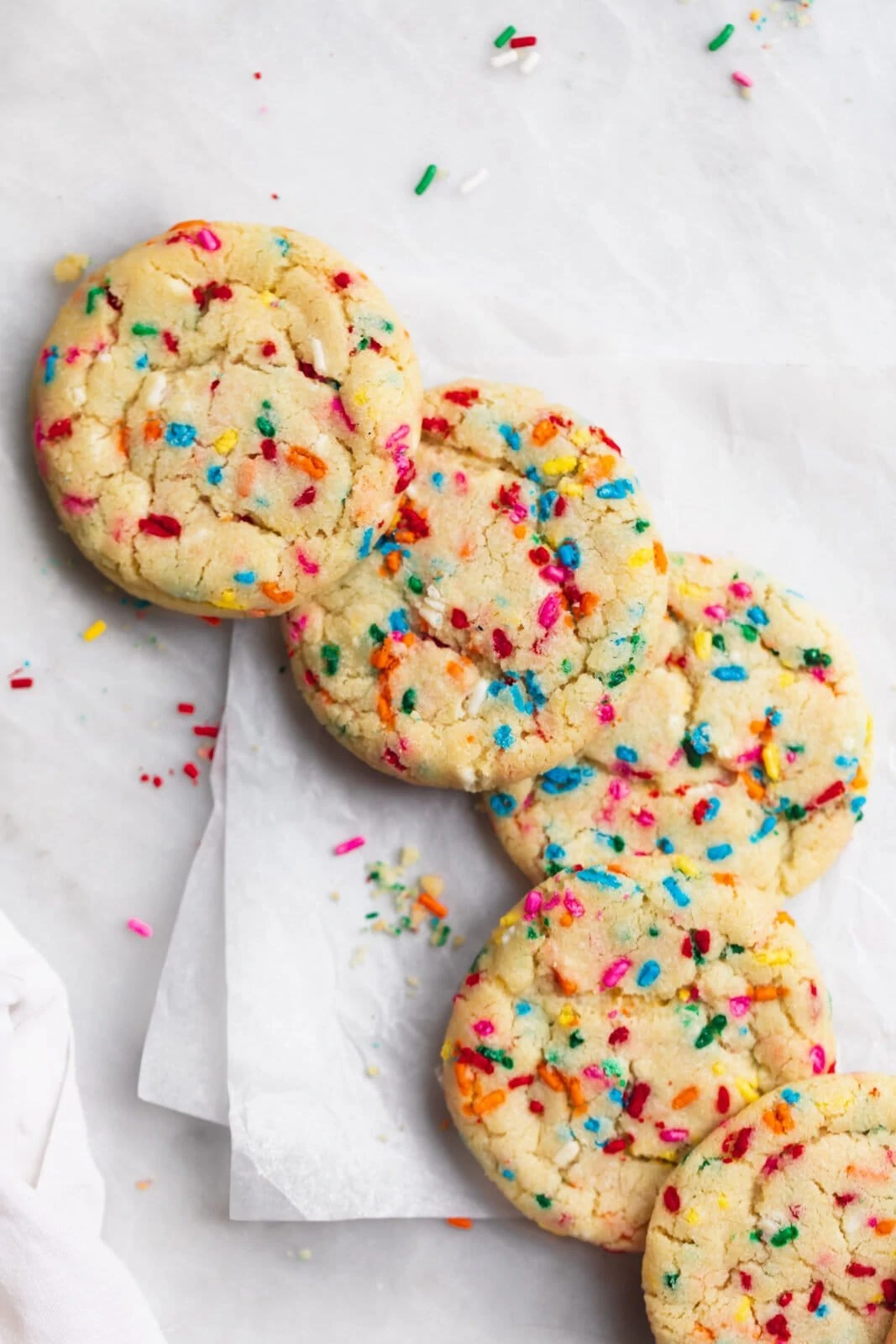 funfetti cookies in with sprinkles on parchment paper