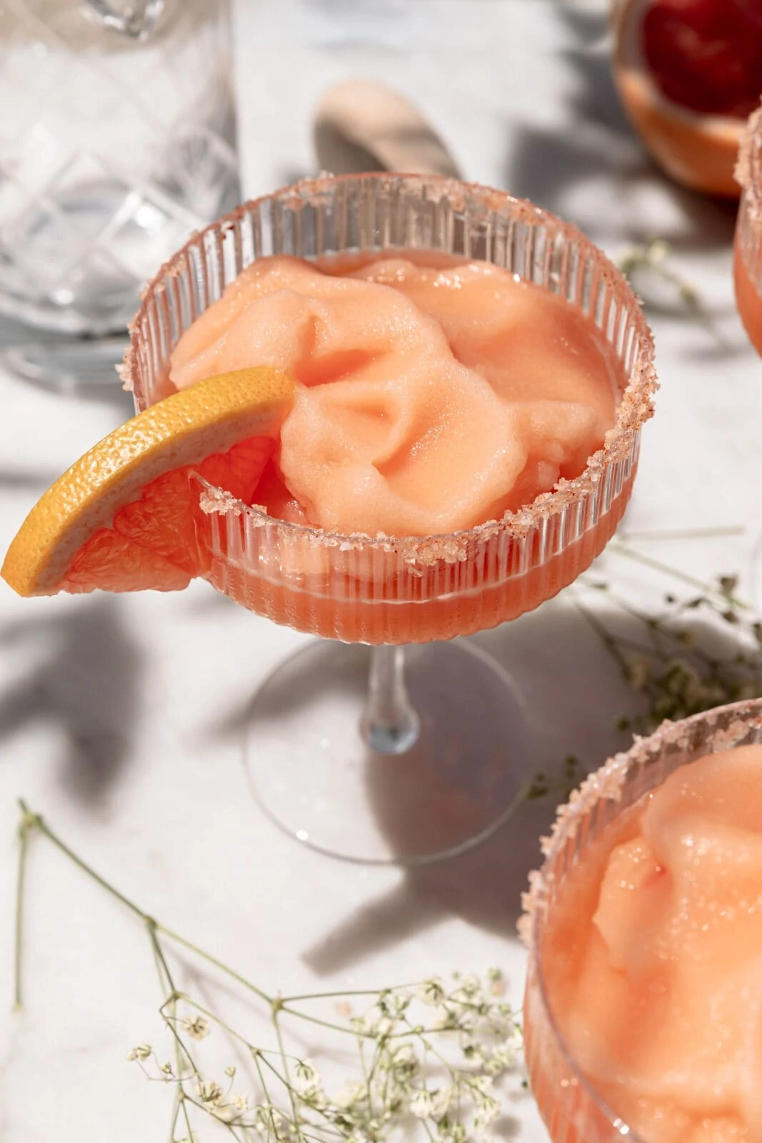frozen paloma in a coupe glass with a salt rim